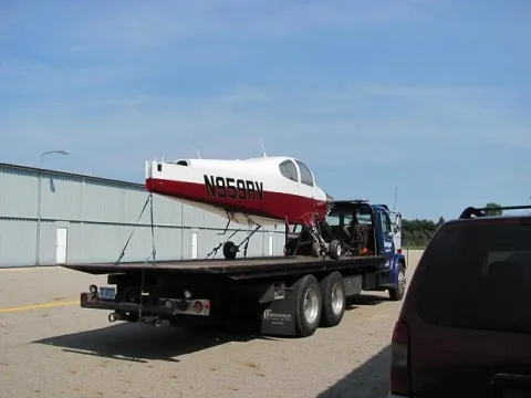 Small airplane secured on a flatbed for equipment transport