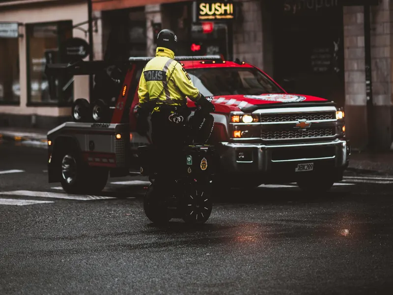 Red wheel-lift tow truck on a city street