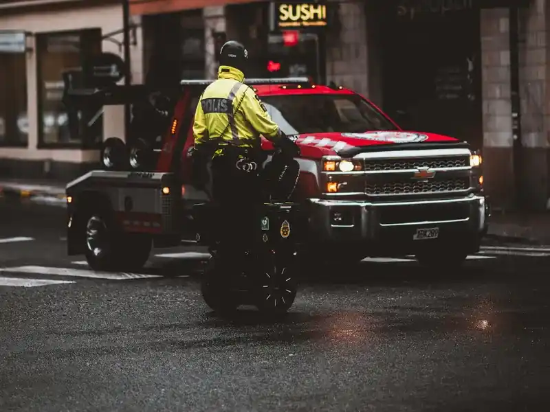Red wheel-lift tow truck on a city street